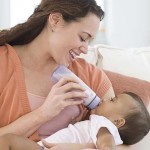 Hispanic mother bottle feeding baby